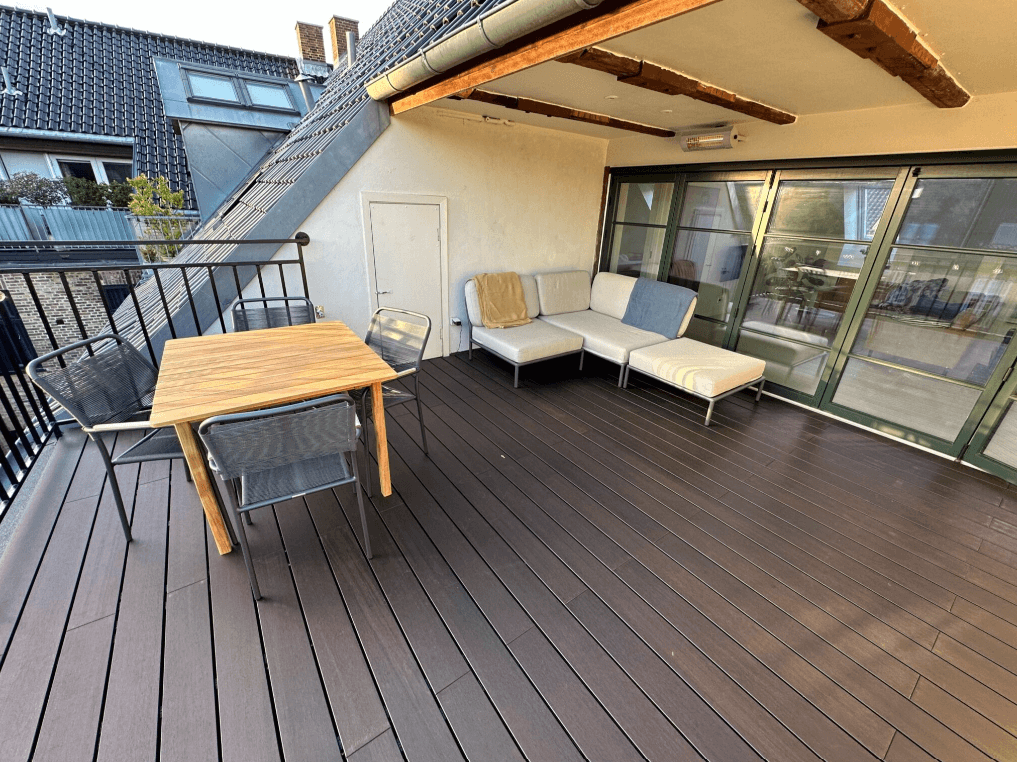 Dachterrasse mit edlen aMbooo Bambus-Terrassendielen in dunkelbraunem Espresso-Ton, hochwertiger Outdoor-Lounge und Esstisch aus Holz. Die pflegeleichten, wetterfesten Bambusdielen sorgen für eine moderne und nachhaltige Gestaltung im Außenbereich. Ideal für Balkon, Terrasse oder Dachgarten