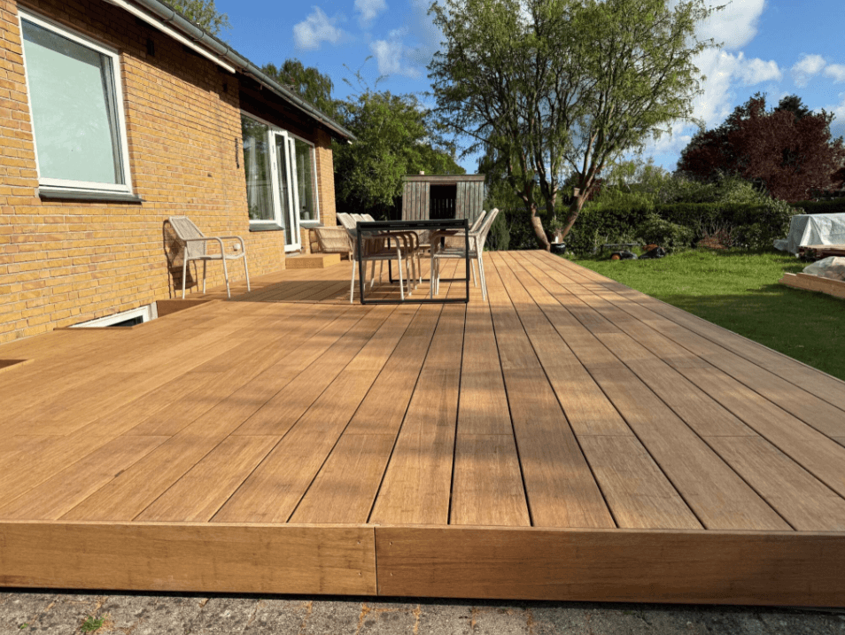 Moderne Terrasse aus sandfarbenen Bambus-Terrassendielen an einem Einfamilienhaus mit Garten – langlebige und pflegeleichte Terrassenlösung von terrassendielen.com.