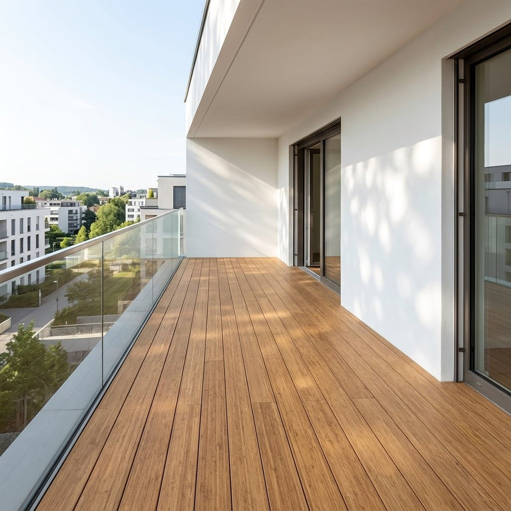 Großzügiger Balkon mit Closeddecking Holzbelag von AMBOOO und Glasgeländer an einem modernen Wohngebäude mit Blick über die Nachbarschaft.