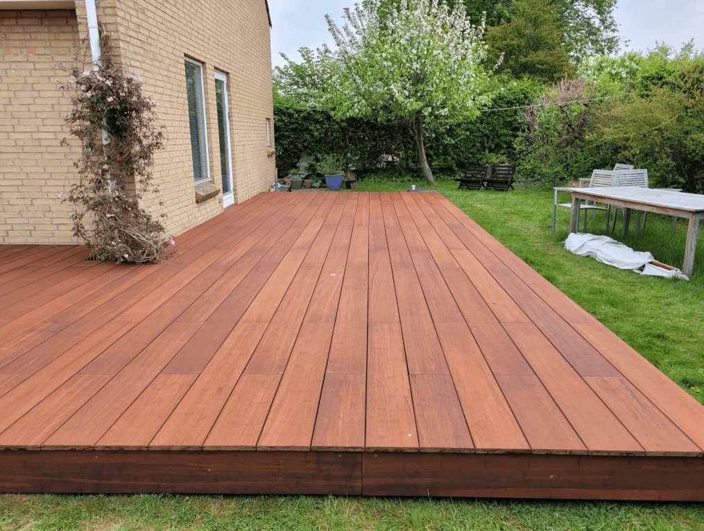 Moderne Terrasse mit XL Terrassendielen aus Bambusholz an einem Einfamilienhaus, hochwertig verlegt in geradlinigem Muster auf grüner Rasenfläche – ideal für langlebige und stilvolle Gartengestaltung.