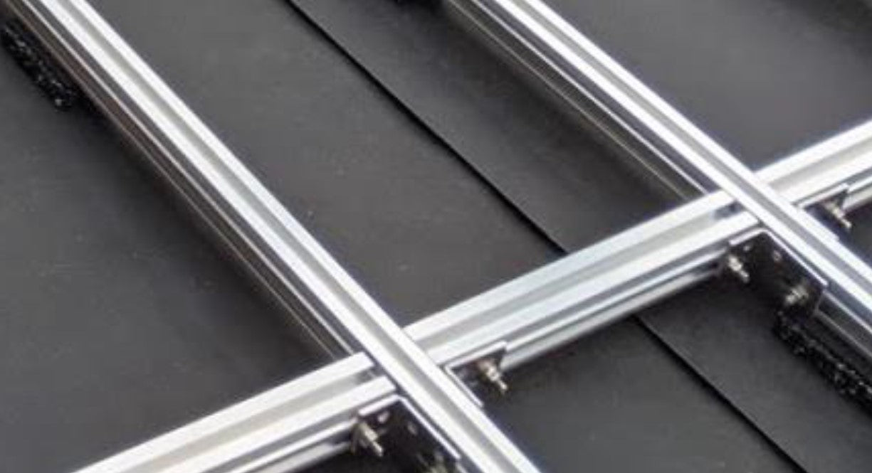 Gekreuzte Aluminiumprofile einer Terrassen-Unterkonstruktion mit montierten Verbindungselementen.