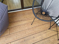 Verlegte Bambus-Terrassendielen in heller Sandfarbe auf einem modernen Balkon mit Sitzmöbeln.