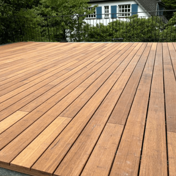 Eine große Terrasse mit der Diele in der Sand.