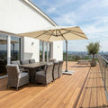 Großzügige Holzterrasse mit Esstisch, Liegen, Glasgeländer und weitem Blick über die Stadt.