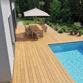 Moderne Poolterrasse aus Colon Closeddecking Terrassendielen mit Essplatz, Sonnenschirm und Blick auf den Garten.