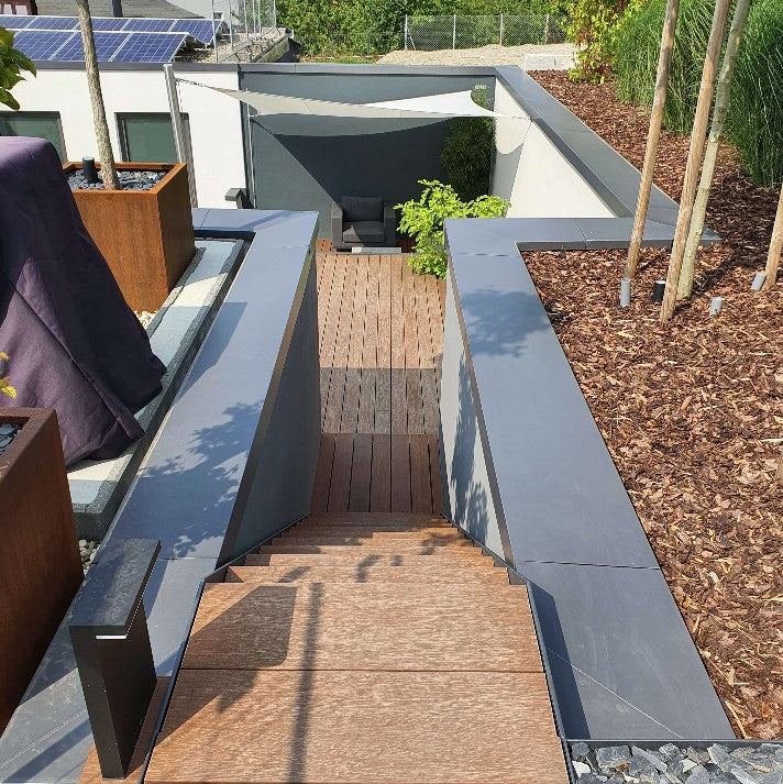 Moderne Außentreppe mit Bambus-Terrassendielen, die zu einer stilvollen Terrasse mit passendem Bambusbelag in einem hochwertig gestalteten Garten führt.