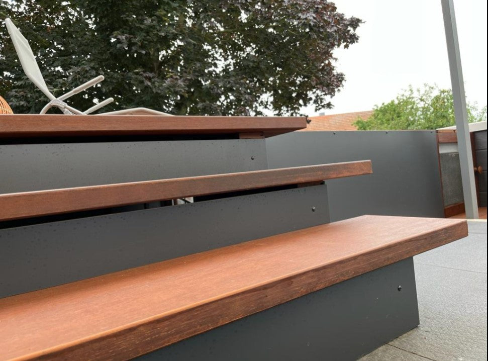 Nahaufnahme einer modernen Außentreppe mit braunen Bambus-Trittstufen und anthrazitfarbenen Setzstufen auf einer Terrasse.