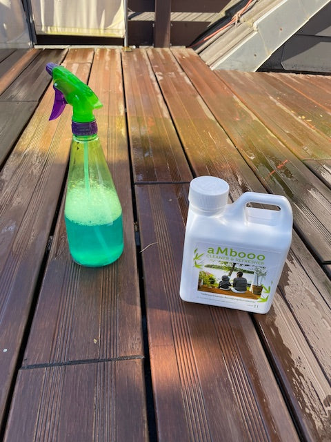 AMBOOO  Bambusreiniger und Sprühflasche auf einer Bambusterrasse während der Reinigung und Pflege.