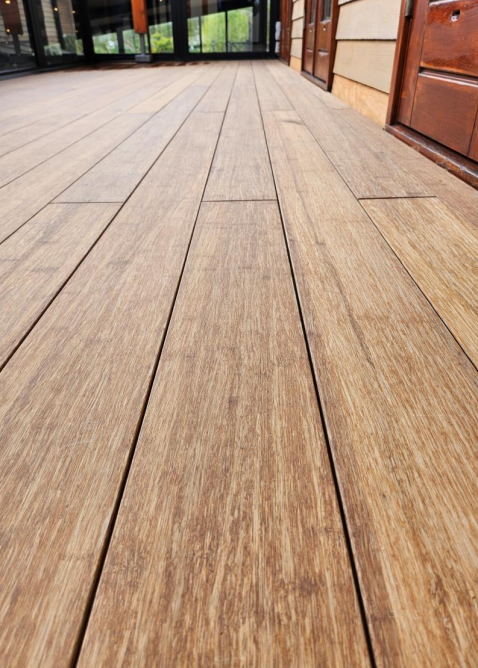 Ein aMbooo Closed Deck Bambus Terrassenbelag mit einer Microfuge verlegt auf einem Balkon - Nahaufnahme- vorgeölt in der Farbe Sand.