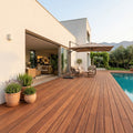 Großzügige Holzterrasse an einem modernen Haus mit Pool, Sitzgruppe, Sonnenschirm und mediterraner Bepflanzung.