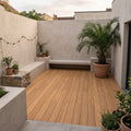 Moderner Innenhof mit Terrassendielen, integrierten Sitzbänken und Pflanzgefäßen – langlebiger und pflegeleichter Terrassenbelag für stilvolle Außenbereiche.