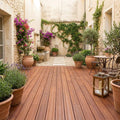 Mediterraner Innenhof mit Bambus-Terrassendielen in der Farbe coffee, blühenden Pflanzen und gemütlichem Sitzplatz – langlebiger, pflegeleichter Terrassenbelag mit natürlicher Holzoptik für stilvolle Außenbereiche.