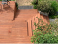 Mehrstufige Bambusholz-Terrasse mit integrierter Treppe und Podesten in einem Garten, aufgenommen aus der Vogelperspektive.